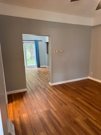 a view of an empty room with wooden floor