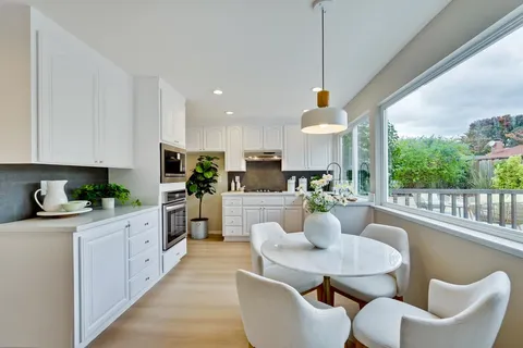 a kitchen with stainless steel appliances granite countertop a stove a kitchen island a table and chairs