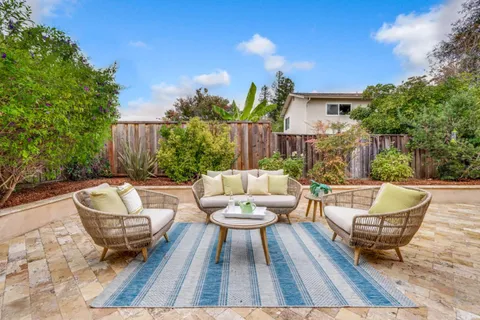 a backyard of a house with fountain table and chairs