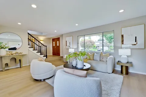 a living room with fireplace furniture and a large window