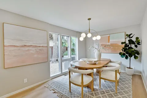 a dining room with furniture potted plants and wooden floor