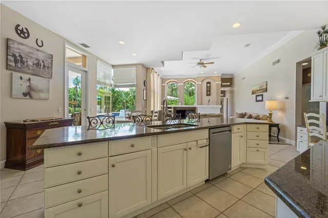 a kitchen with granite countertop white cabinets and stainless steel appliances