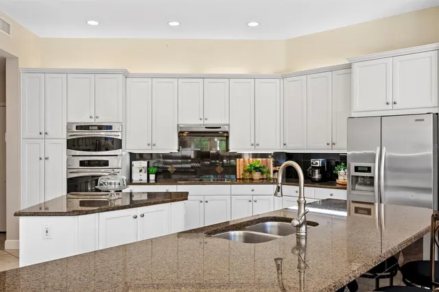 a living room with furniture a chandelier and kitchen view