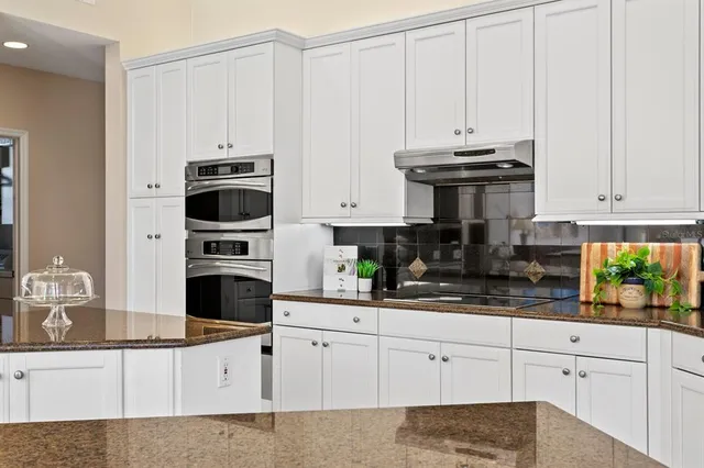 a living room with furniture kitchen view and a chandelier