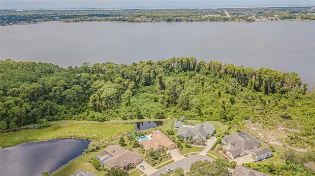 an aerial view of a house with outdoor space and lake view