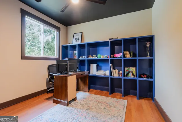 a view of a workspace with furniture and a bookshelf