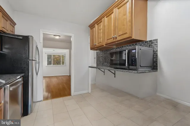 a kitchen with stainless steel appliances granite countertop a refrigerator and a stove