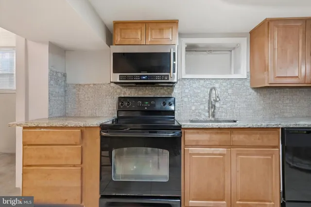 a kitchen with stainless steel appliances granite countertop a stove microwave and oven
