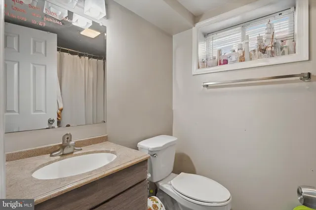 a bathroom with a toilet a sink and mirror