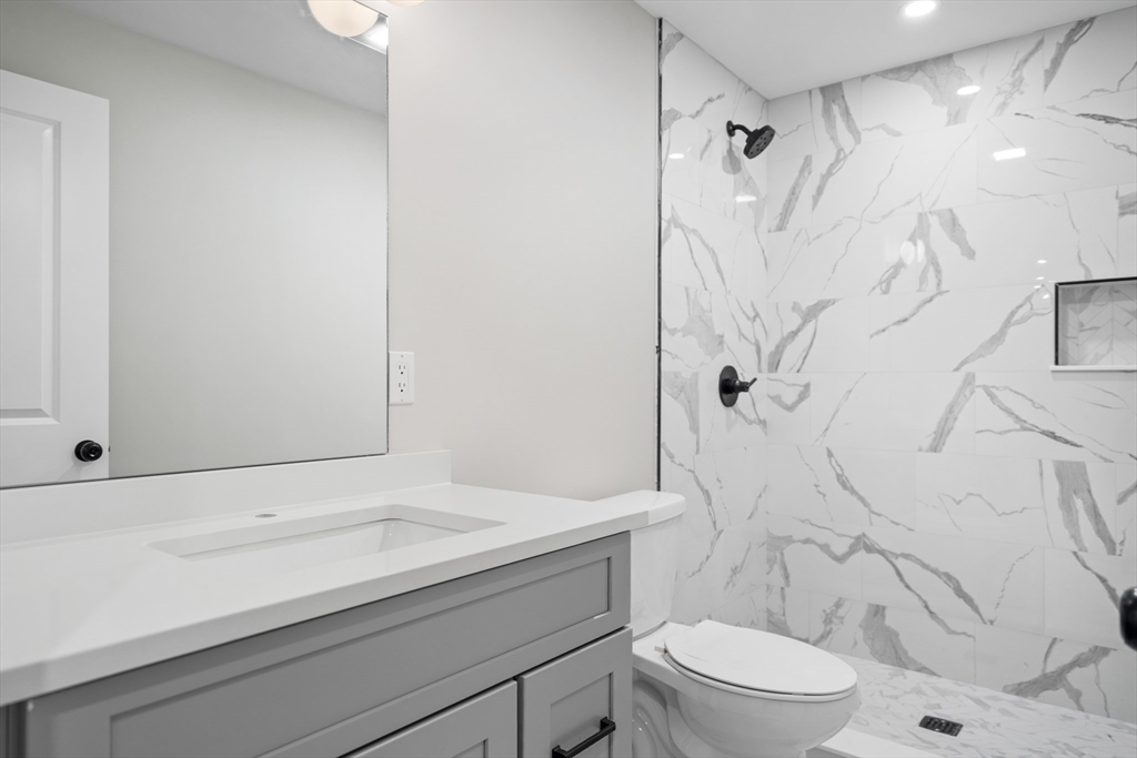 59 Nottinghill Road, Unit 59 Boston, MA 02135 - Photo 5 of 10 a bathroom with a sink a toilet and shower