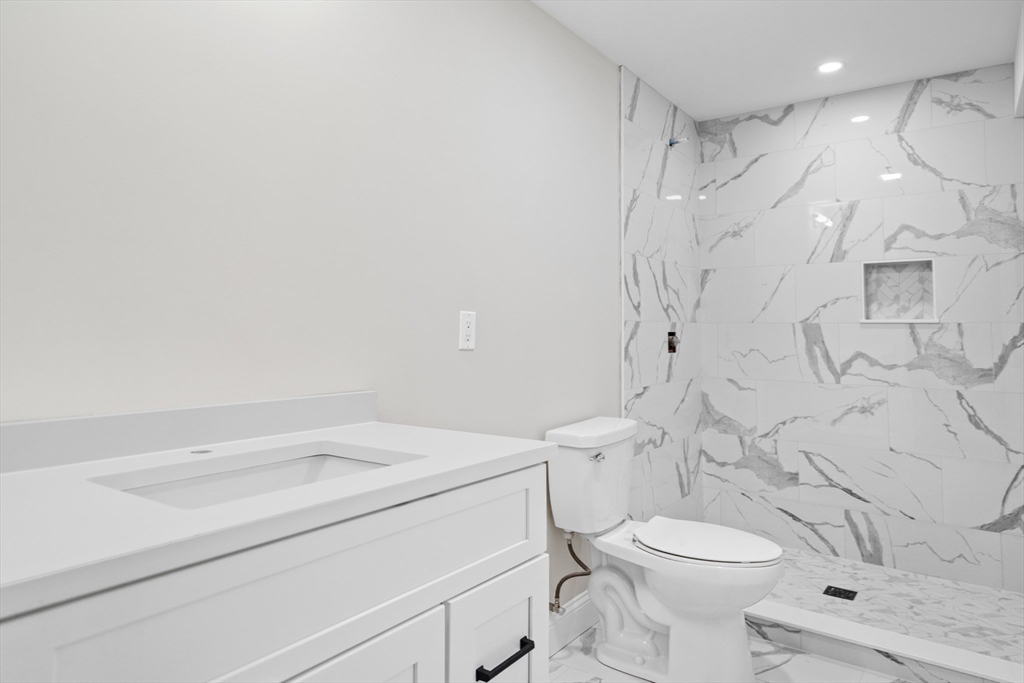 59 Nottinghill Road, Unit 59 Boston, MA 02135 - Photo 9 of 10 a bathroom with a sink a toilet and shower