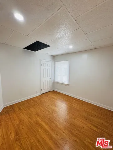 an empty room with wooden floor and white walls