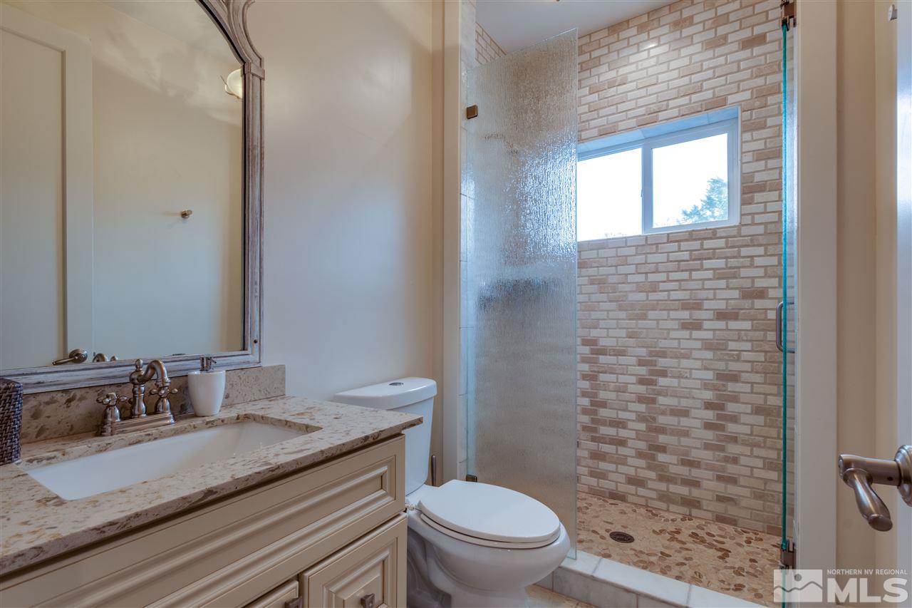 1663 Shangri-La Drive Reno, NV 89509 - Photo 18 of 30 a bathroom with a granite countertop sink toilet and shower