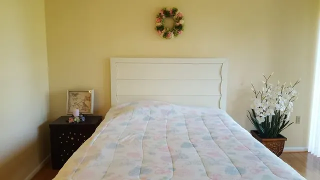 a bedroom with a bed and a potted plant