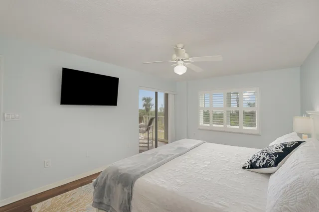 a bedroom with a bed window and a flat screen tv