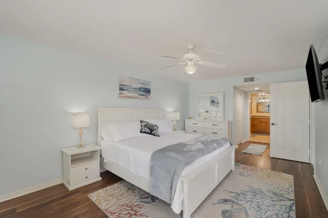 a spacious bedroom with a bed and a flat screen tv