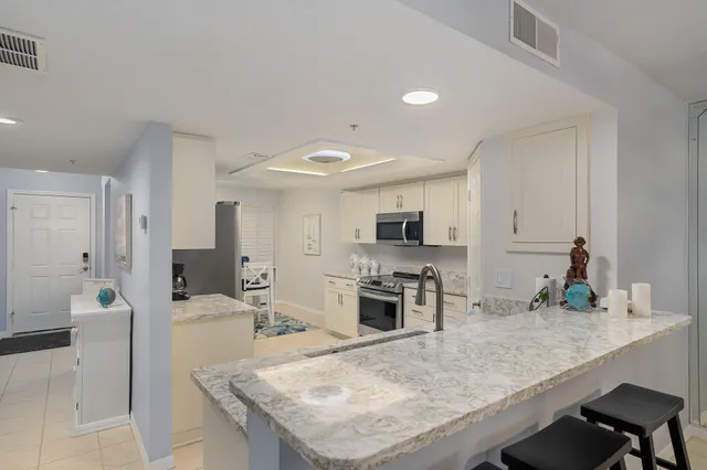 a kitchen with kitchen island a sink stove and refrigerator