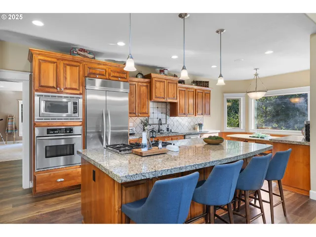 a kitchen with stainless steel appliances granite countertop a stove a sink and a refrigerator