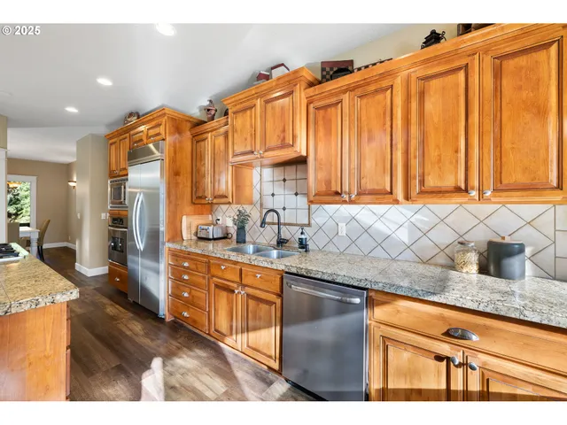 a kitchen with stainless steel appliances granite countertop a sink and cabinets