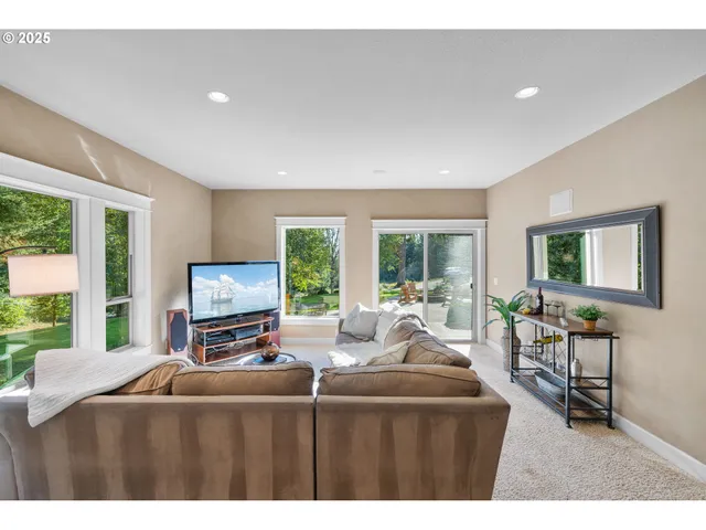 a living room with furniture a large window and a flat screen tv