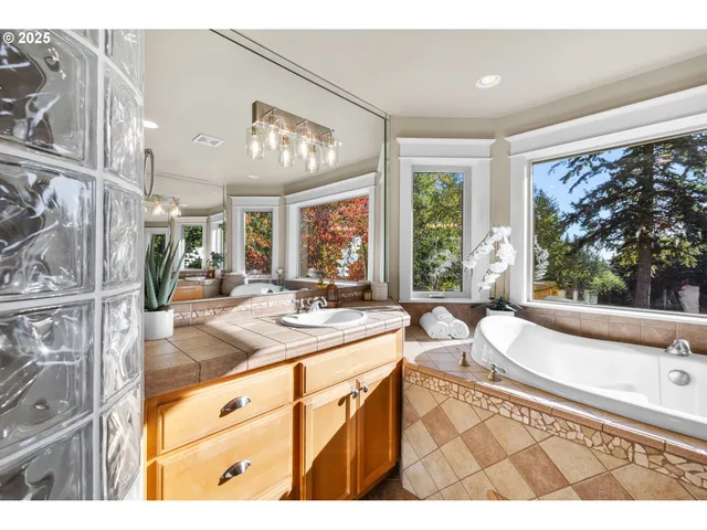 a bathroom with a granite countertop sink mirror and a bath tub