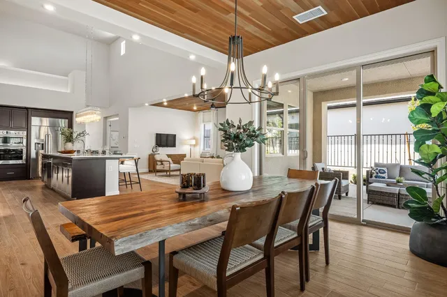 a dining room with furniture a chandelier and wooden floor