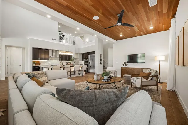 a living room with furniture kitchen view and a chandelier