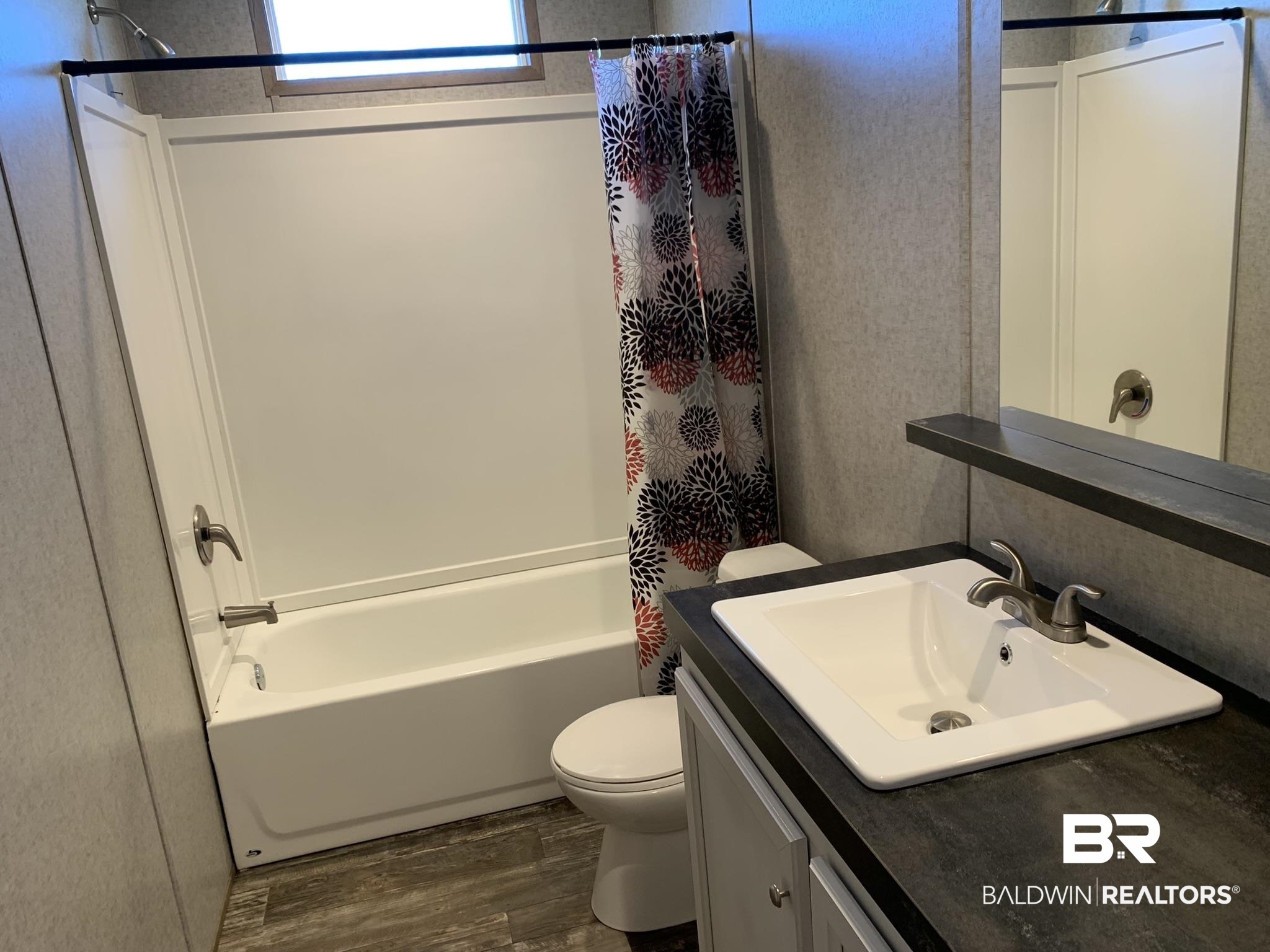 16876 County Road 87 Elberta, AL 36530 - Photo 11 of 13 Full bathroom with wood-type flooring, vanity, toilet, and shower / tub combo