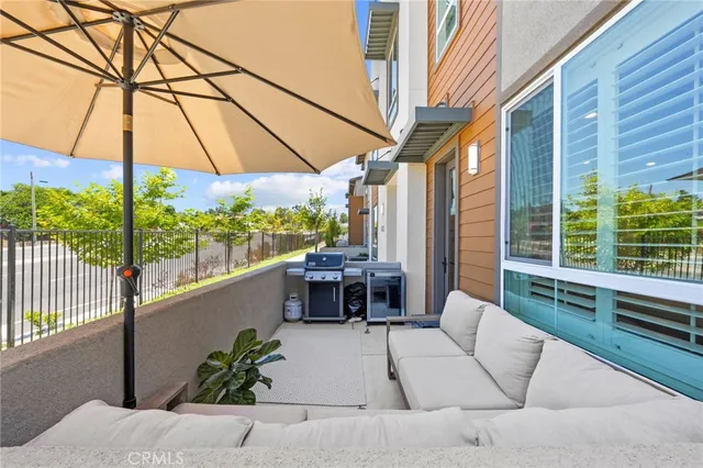 a patio with a table and chairs under an umbrella