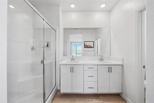 a bathroom with a double vanity sink a mirror and a bathtub