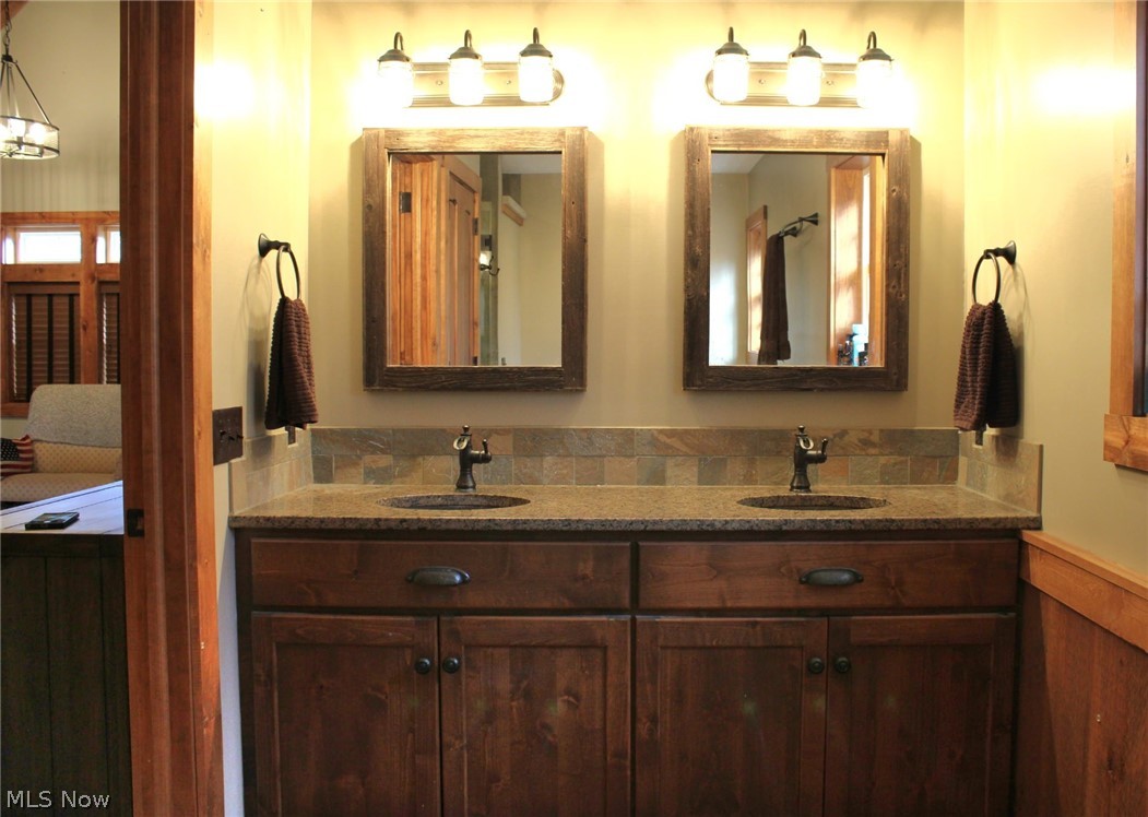3989 Court Road Wakeman, OH 44889 - Photo 16 of 36 Bathroom with double vanity, wainscoting, hammered copper sinks, and wooden walls
