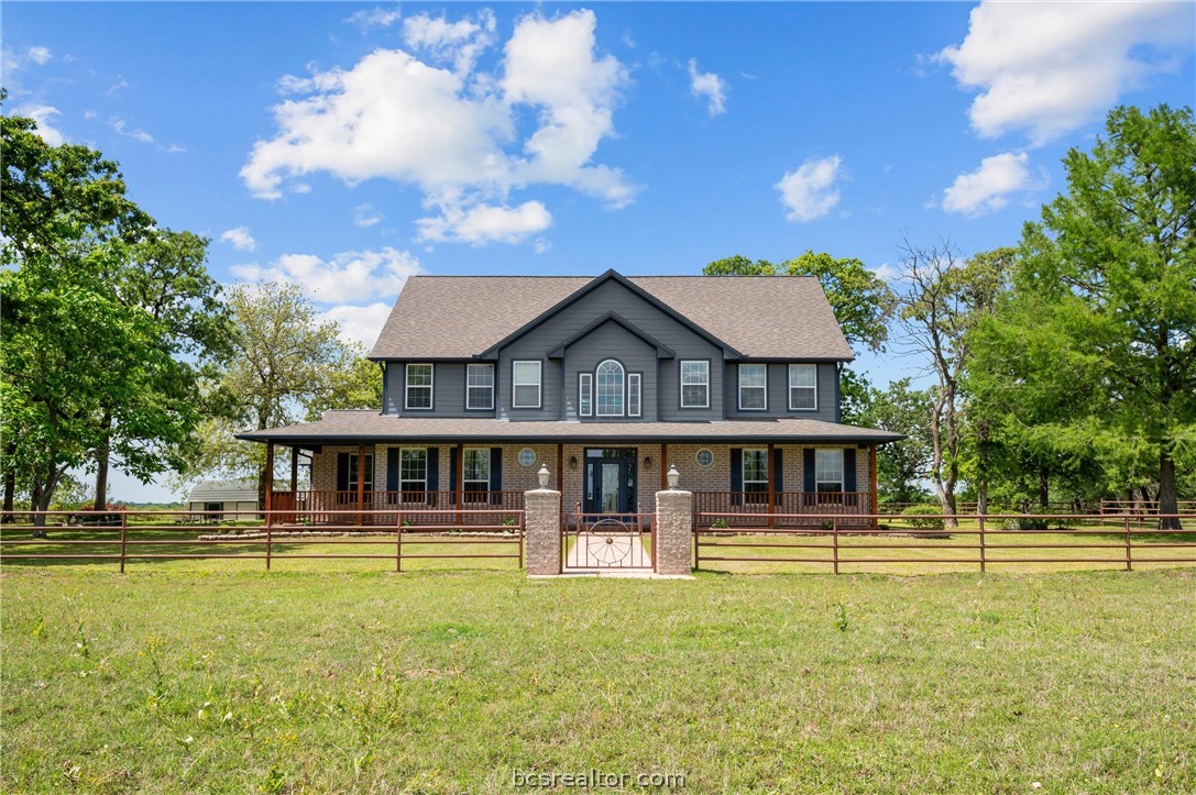 6400 Koppe Bridge Road College Station, TX 77845 - Photo 1 of 47 Colonial inspired home with a porch, a gate, and a fenced front yard.