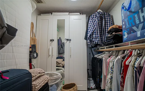 a view of walk in closet with clothes and shoes
