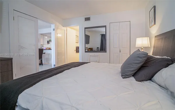 a large bed sitting in a bedroom and a large mirror