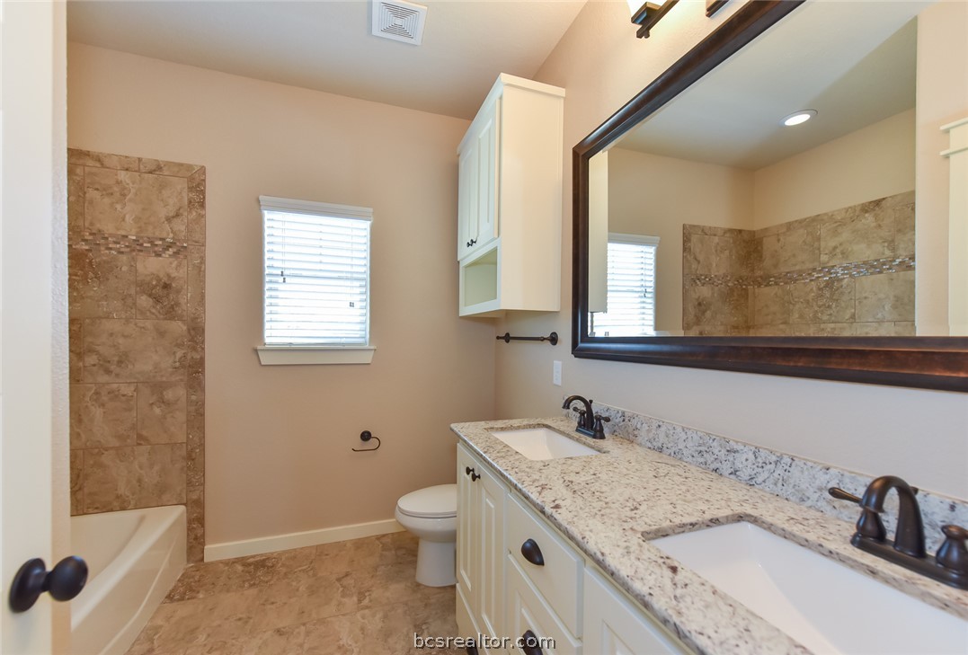 2136 Rockcliffe Loop College Station, TX 77845 - Photo 12 of 16 a bathroom with a granite countertop sink toilet and shower