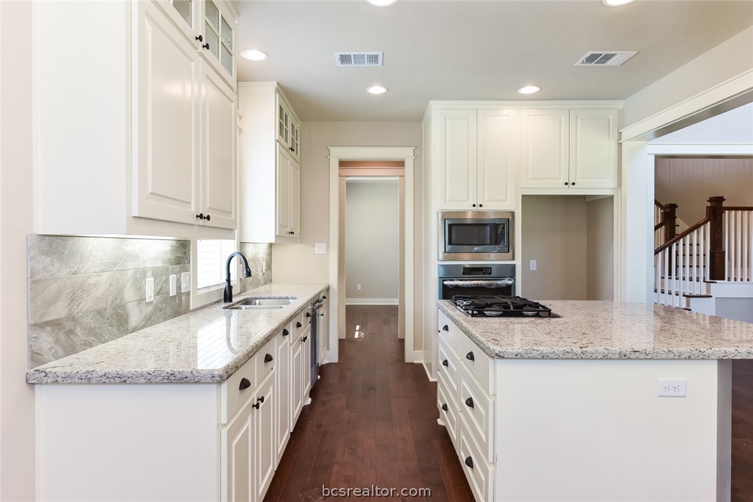 2136 Rockcliffe Loop College Station, TX 77845 - Photo 4 of 16 a kitchen with granite countertop a sink a counter top space stainless steel appliances and cabinets
