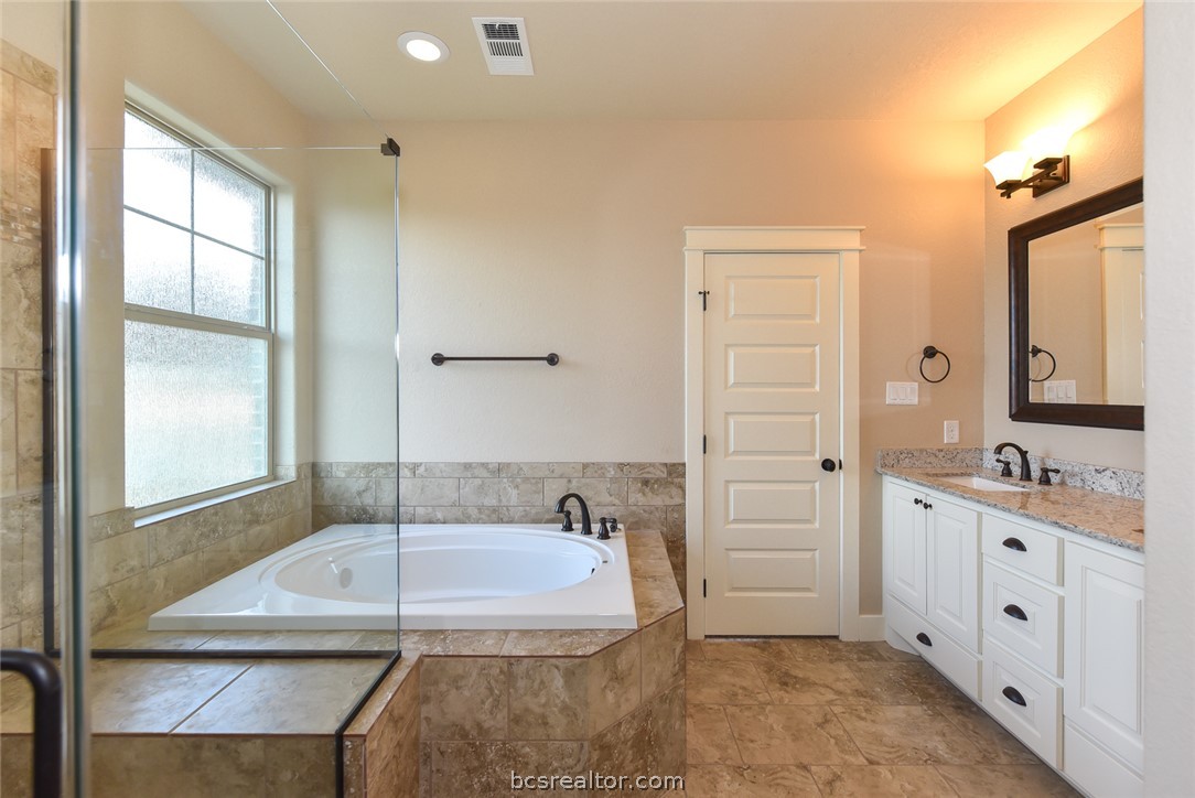 2136 Rockcliffe Loop College Station, TX 77845 - Photo 9 of 16 a bathroom with a granite countertop sink a mirror and a bathtub