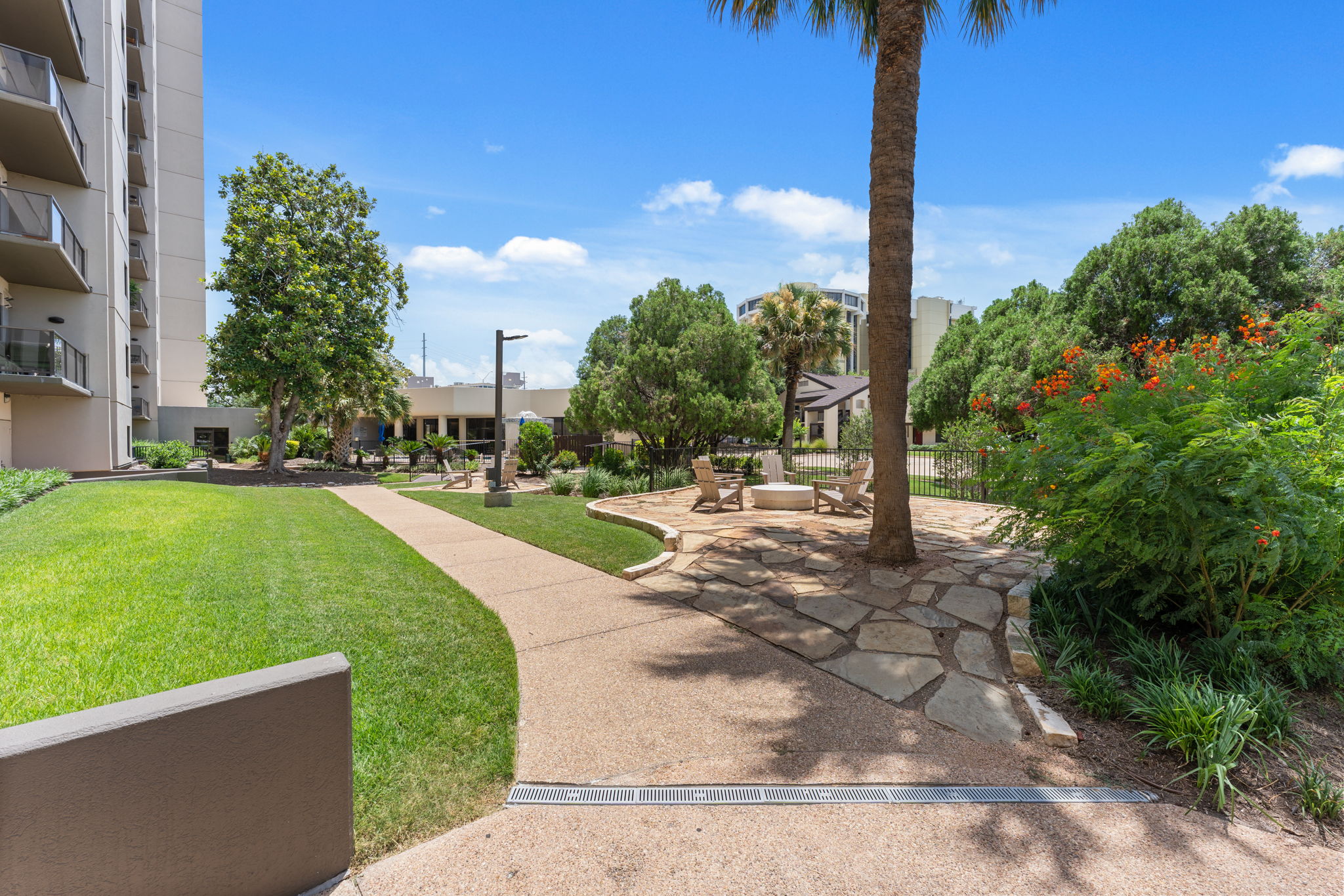 40 North Interstate Highway 35, Unit 11B2 Austin, TX 78701 - Photo 24 of 28 A well-maintained outdoor lounge area with lush green lawn and inviting stone patio.