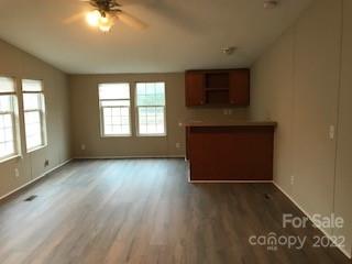 327 Rankin Hill Road Troutman, NC 28166 - Photo 3 of 9 an empty room with wooden floor fan and windows