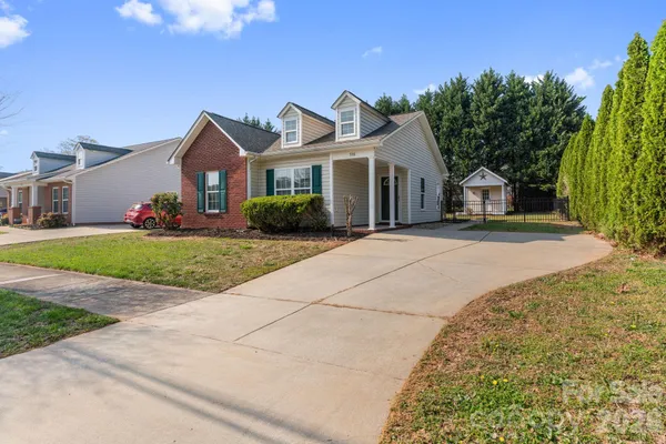 a front view of a house with a yard and potted plants