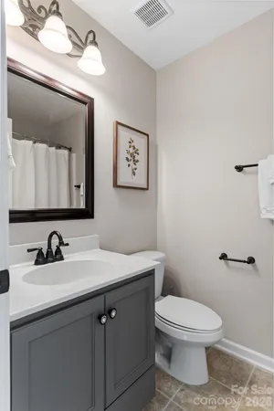 a bathroom with a toilet a sink and mirror