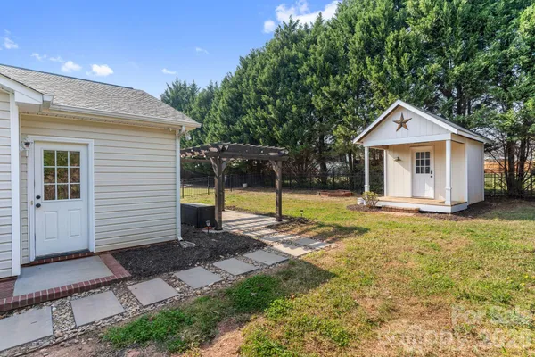 a view of a house with backyard and tree