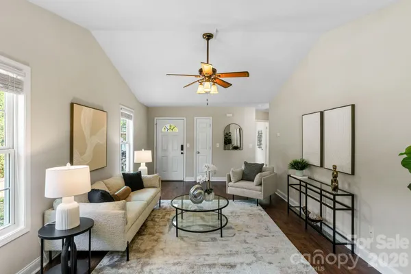 a living room with furniture chandelier and a window