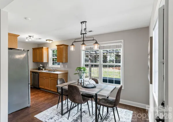 a dining room with furniture a chandelier and wooden floor