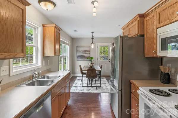a kitchen with stainless steel appliances granite countertop a sink stove and refrigerator