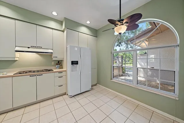 a kitchen with stainless steel appliances granite countertop a refrigerator a oven and a sink with cabinets