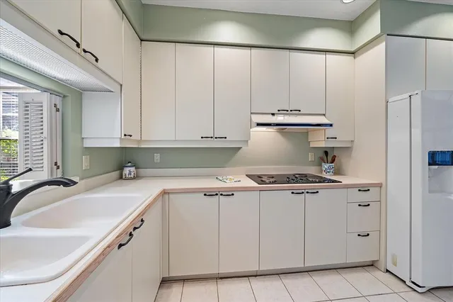 a kitchen with granite countertop white cabinets and white appliances