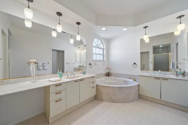 a large bathroom with a sink a large mirror and a bathtub