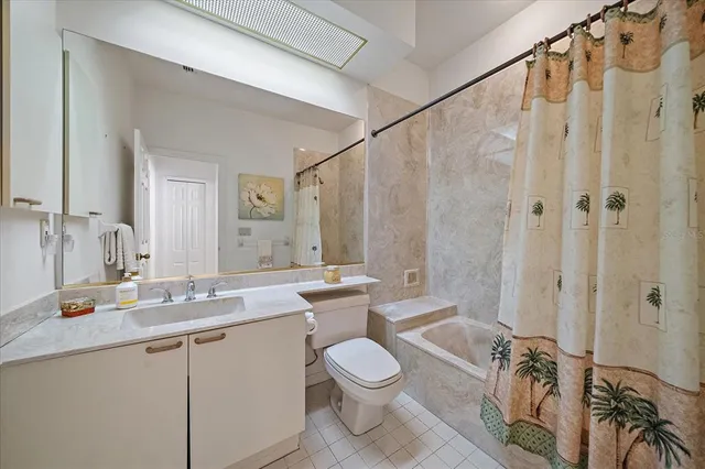 a bathroom with a granite countertop sink mirror vanity and toilet