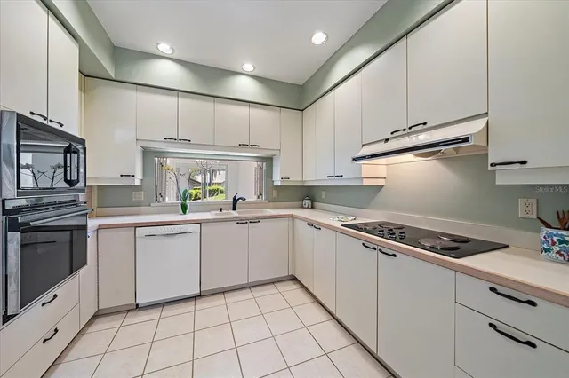 a kitchen with cabinets appliances a sink and a counter top space